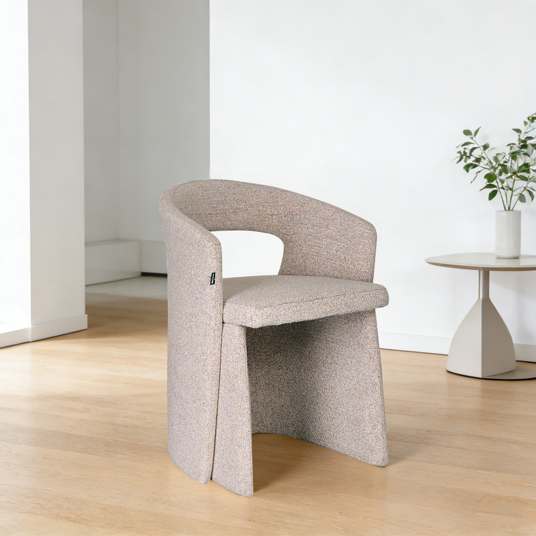 Silla Pavia gris vista en perspectiva dentro de un cuarto con mesa lateral a un lado sobre piso de madera