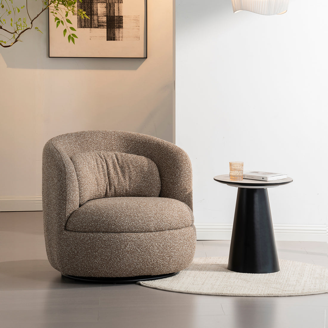 Sillón Victoria dentro de un cuarto con paredes blanca, debajo de un cuadro artístico, a lado una mesa lateral color negro con un vaso de agua y un libro